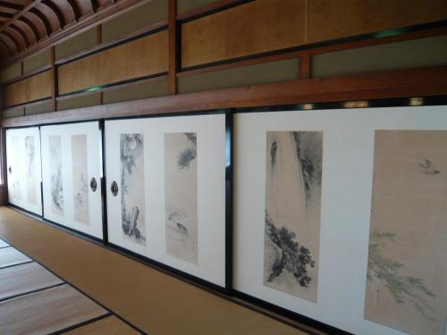 a row of drawings on a wall in a room at Seikiro Ryokan Historical Museum Hotel in Miyazu