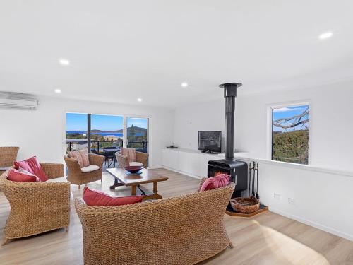 a living room with chairs and a wood stove at Island View Large Family Home Pool WI FI and Sweeping Views of Fingal in Fingal Bay
