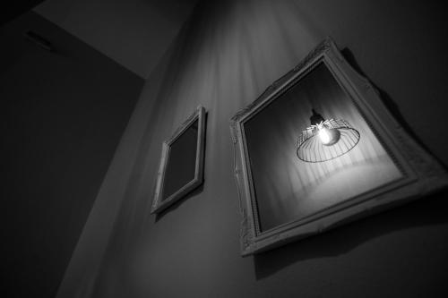 a mirror hanging on a wall with a light at Magdalene's Premium Apartments in Ofrínion