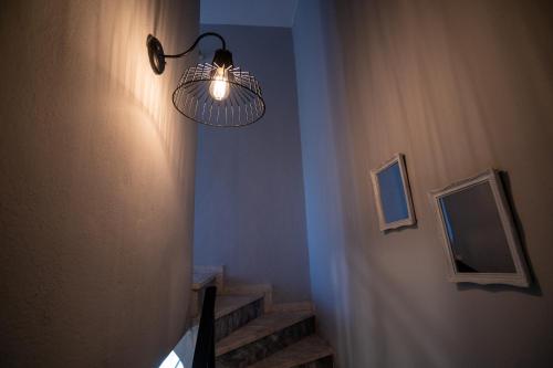 a staircase with a light hanging from a wall at Magdalene's Premium Apartments in Ofrínion