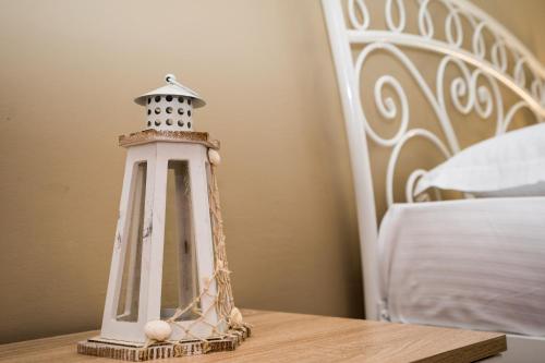 a small lighthouse sitting on a table next to a bed at Magdalene's Premium Apartments in Ofrínion