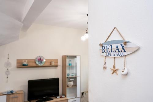 a surfboard sign hanging on a wall in a room at Magdalene's Premium Apartments in Ofrínion