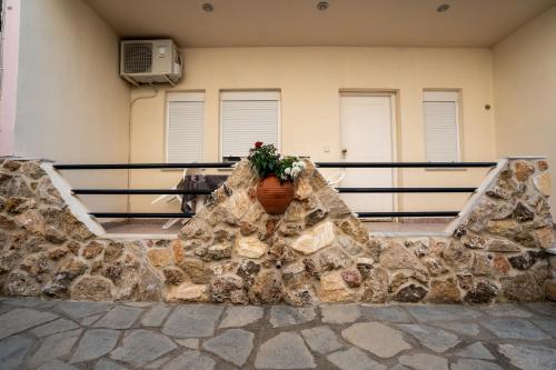 a stone wall with a flower pot on it at Magdalene's Premium Apartments in Ofrínion