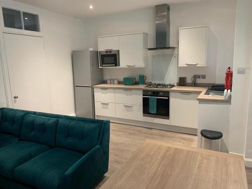 a living room with a green couch in a kitchen at Woodvale Flat, Renton, Loch Lomond in Renton