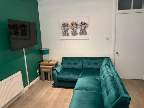 una sala de estar con un sofá verde en una habitación en Woodvale Flat, Renton, Loch Lomond en Renton