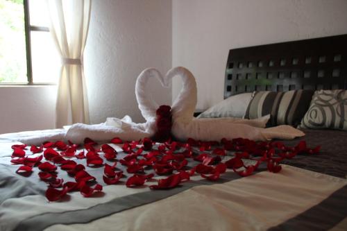 a bunch of red rose petals on a bed at Tu cabaña Cuernavaca - hospedaje by Arcadia in Cuernavaca