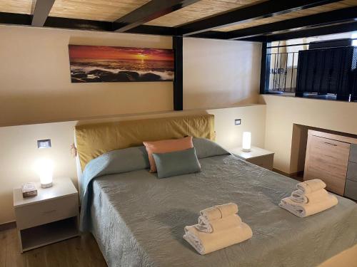 ein Schlafzimmer mit einem Bett mit zwei Handtüchern darauf in der Unterkunft SUNSET LOFT in Milazzo