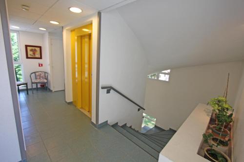 a hallway in an office building with a yellow door at Beau Rivage in Charavines