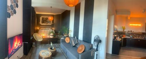 een woonkamer met een blauwe bank en een bar bij Mastersuite at Antwerp Theaterdistrict in Antwerpen