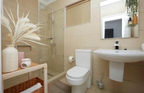 a bathroom with a toilet and a sink at Hilton Premium Suite, Labone in Accra
