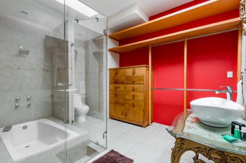 a bathroom with a tub and a sink and a shower at Suites Cuija Coyoacan in Mexico City