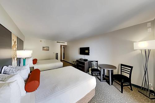 een hotelkamer met twee bedden en een tafel en stoelen bij Aqua Palms Waikiki Ocean View Lanai Parking Included in Honolulu