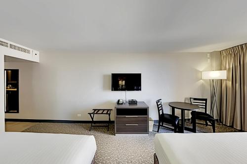 a hotel room with a desk and a table and chairs at Aqua Palms Waikiki Ocean View Lanai Parking Included in Honolulu