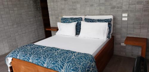 a bed with blue and white sheets and pillows at Casa frente al Mar EL PARAISO, Cojimies in Pedernales