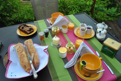 a table with plates of food and cups of coffee at Chambre d'hôtes Le Cadran des Chauvelles in Nevers