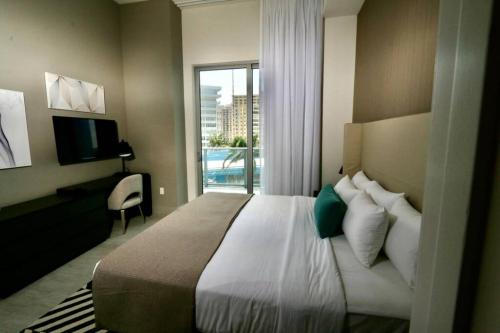 een slaapkamer met een groot bed en een raam bij Luxury Two Bed Two Bath Beach Resort Condo 35 USD resort fee per day in Hollywood