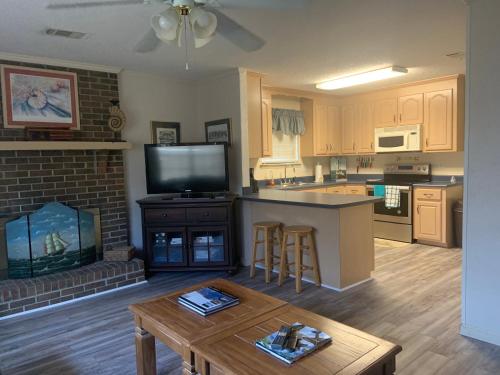 a kitchen and living room with a tv and a table at Cozy comfortable & convenient in Pensacola
