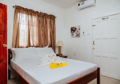a bedroom with a bed with a yellow towel on it at Wanigi Guesthouse in Punta Gorda