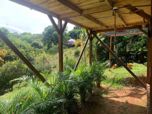 a wooden pergola with a view of a field at Eco-Glamping Shalom in Mariquita