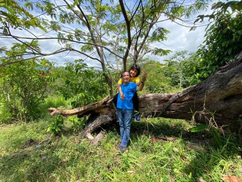 two children standing next to a fallen tree at Eco-Glamping Shalom in Mariquita