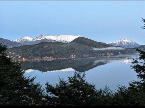 widok na jezioro z pokrytymi śniegiem górami w obiekcie Albanta casa con costa en Bariloche w mieście Bariloche