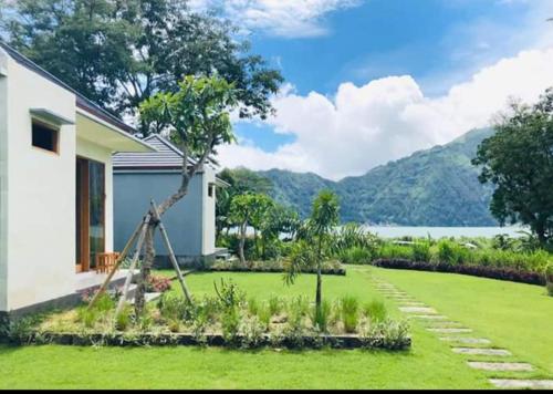 een tuin met groen gras en een huis bij Segara Healing Villa in Kintamani