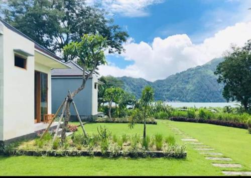 a garden with green grass and a house at Segara Healing Villa in Kintamani
