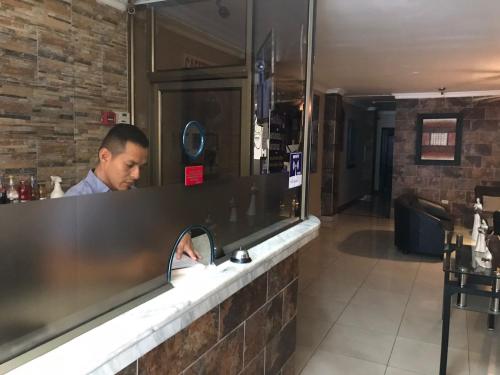 a man sitting at a counter in a restaurant at Hostal Bellagio in Guayaquil