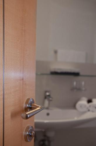 a bathroom door with a sink and a mirror at Alpina Appartements in Nauders