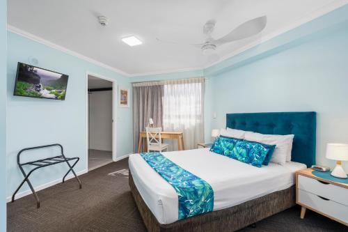 a bedroom with a large bed with blue walls at Sovereign on the Gold Coast in Gold Coast