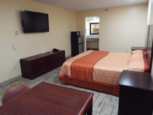 a hotel room with two beds and a flat screen tv at Texas Inn Harlingen in Harlingen