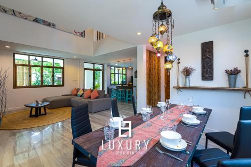 a dining room and living room with a table and chairs at Modern Pool villa, 4 Bedroom Close to Beach - HV in Hua Hin