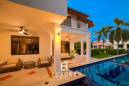 a villa with a swimming pool and a house at Modern Pool villa, 4 Bedroom Close to Beach - HV in Hua Hin
