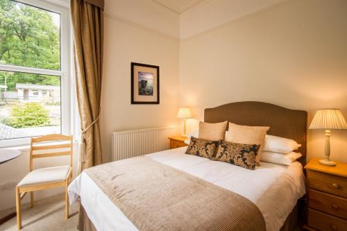 a bedroom with a large bed and a window at The Arran Lodge & Arran Sleep Huts in Lamlash