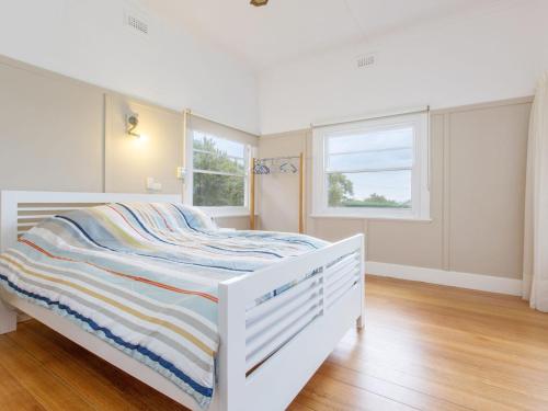 a white bed in a room with a window at BEACHSIDE GETAWAY DROMANA in Dromana