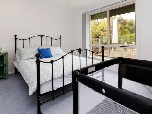 a bedroom with a black bed and a window at Dromana Bay Views Dromana in Dromana