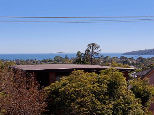 a house with the ocean in the background at Dromana Bay Views Dromana in Dromana