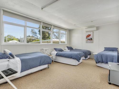 a bedroom with three beds and two windows at Bethany Bay Mount Martha in Mount Martha