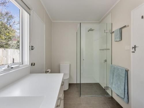 a white bathroom with a shower and a sink at Bethany Bay Mount Martha in Mount Martha