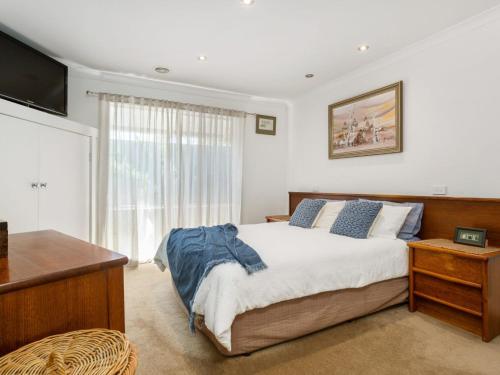 a bedroom with a large bed and a television at Karinya Mornington in Mornington
