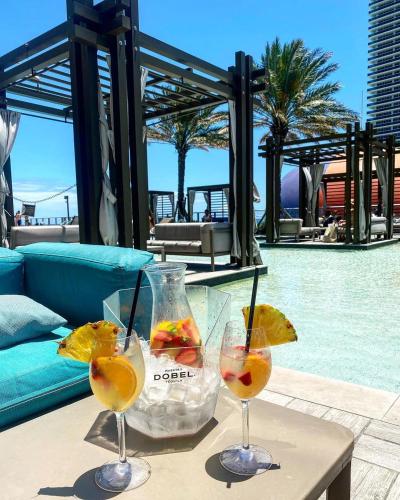 two glasses of wine on a table next to a pool at Million Dollar View at Hyde Resort And Residences in Hollywood