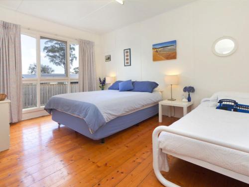 a bedroom with two beds and a large window at Home Sweet Home Mount Martha in Mount Martha