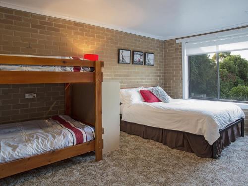 two bunk beds in a room with a brick wall at Roanjoka Dromana in Dromana