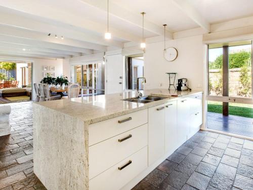 een open keuken met witte kasten en een groot eiland bij WAIKIKI BLAIRGOWRIE in Blairgowrie
