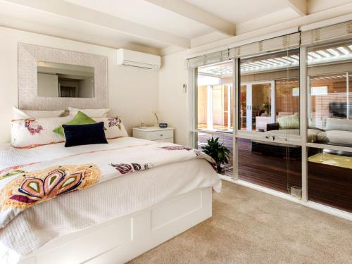een slaapkamer met een bed en een groot raam bij WAIKIKI BLAIRGOWRIE in Blairgowrie