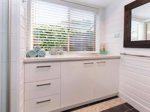 a white bathroom with a sink and a window at Moonah Sands Rye in Rye