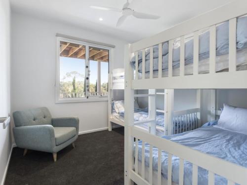 ein Schlafzimmer mit einem Etagenbett und einem Stuhl in der Unterkunft Windspray Mount Martha in Mount Martha