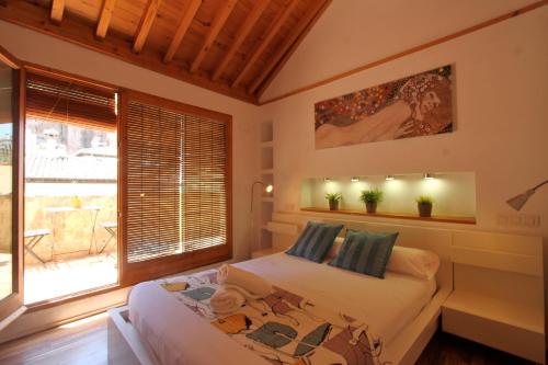 um quarto com uma cama e uma grande janela em Apartamento Duplex Gomerez 39 em Granada
