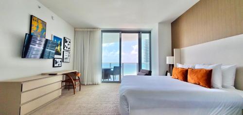 a hotel room with a large bed and a desk and window at Million Dollar View at Hyde Resort And Residences in Hollywood
