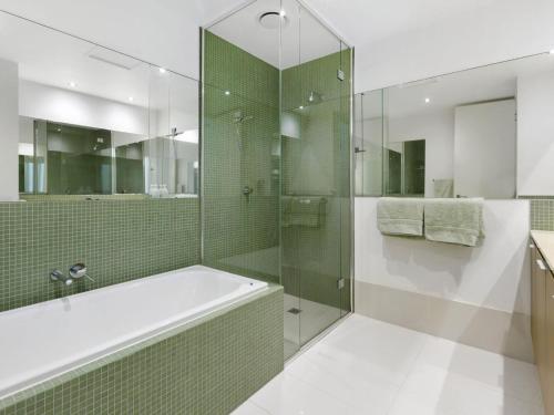 a bathroom with a tub and a glass shower at Marina View in Safety Beach